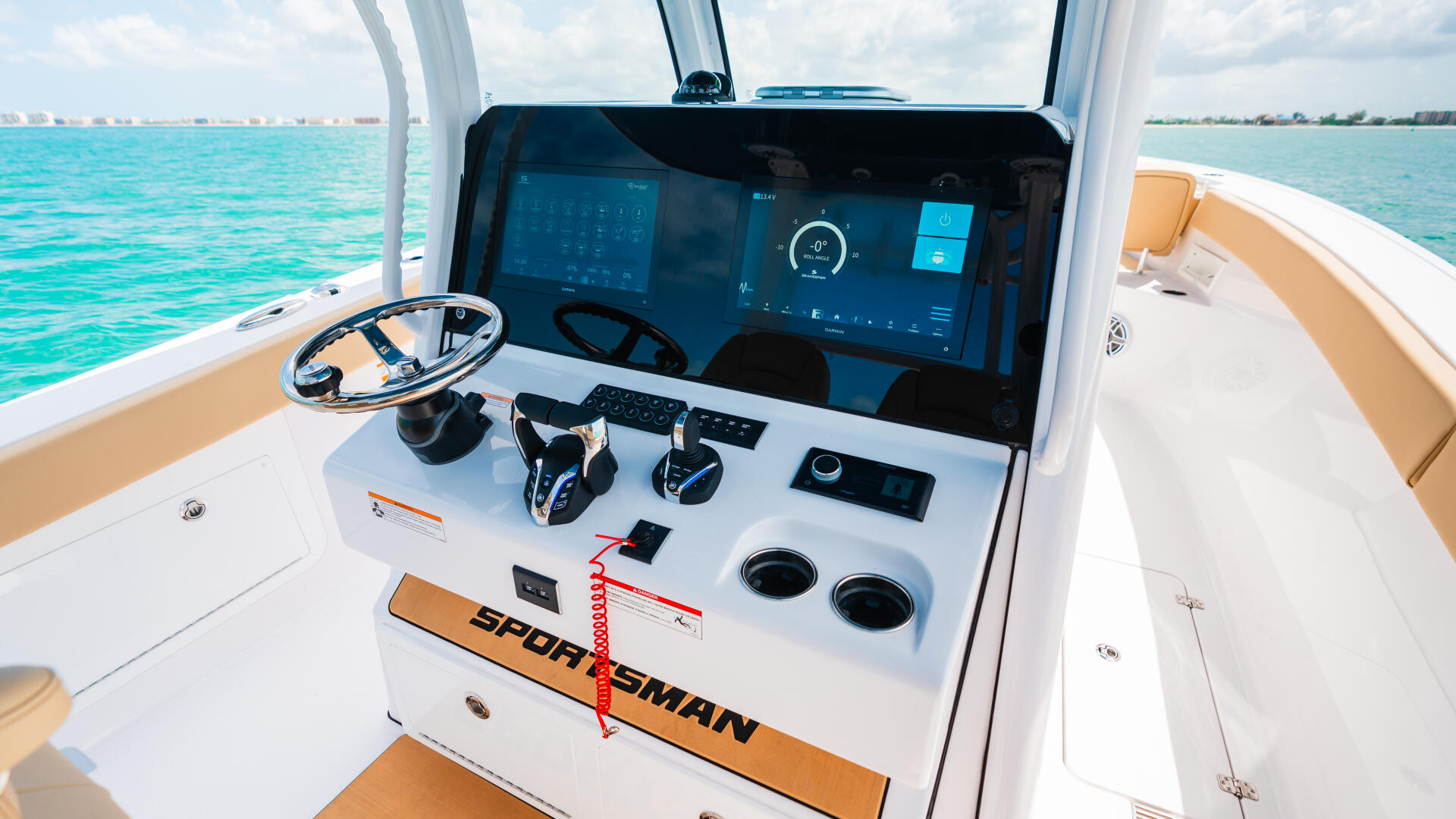 Sportsman boat helm with digital display, wheel, and control panel overlooking turquoise water