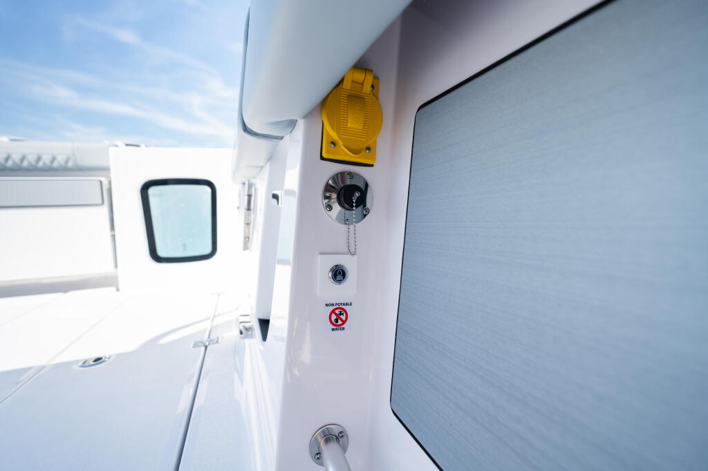 Boat cabin wall showing yellow light fixture, electrical gauges, and safety controls