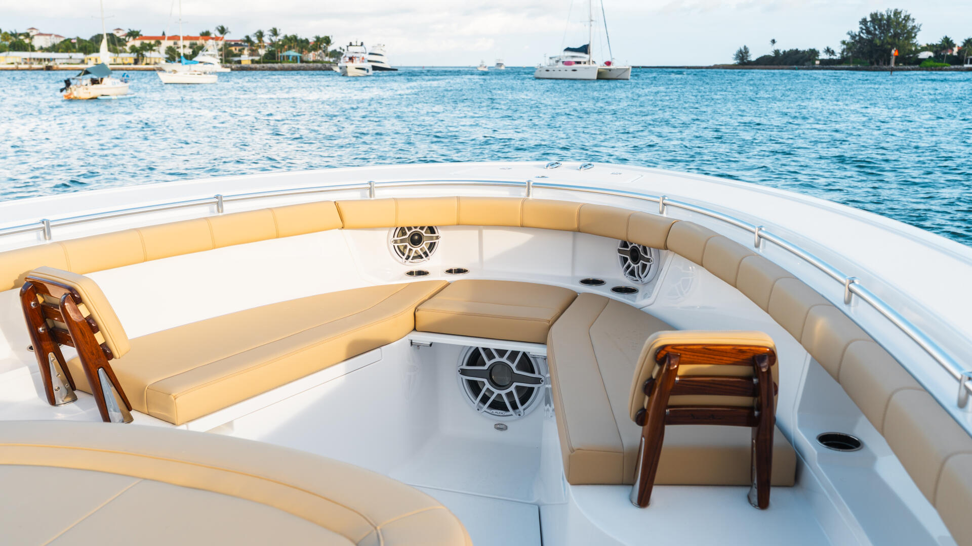 Spacious bow seating area with cream leather cushions and wooden accents overlooking a calm marina