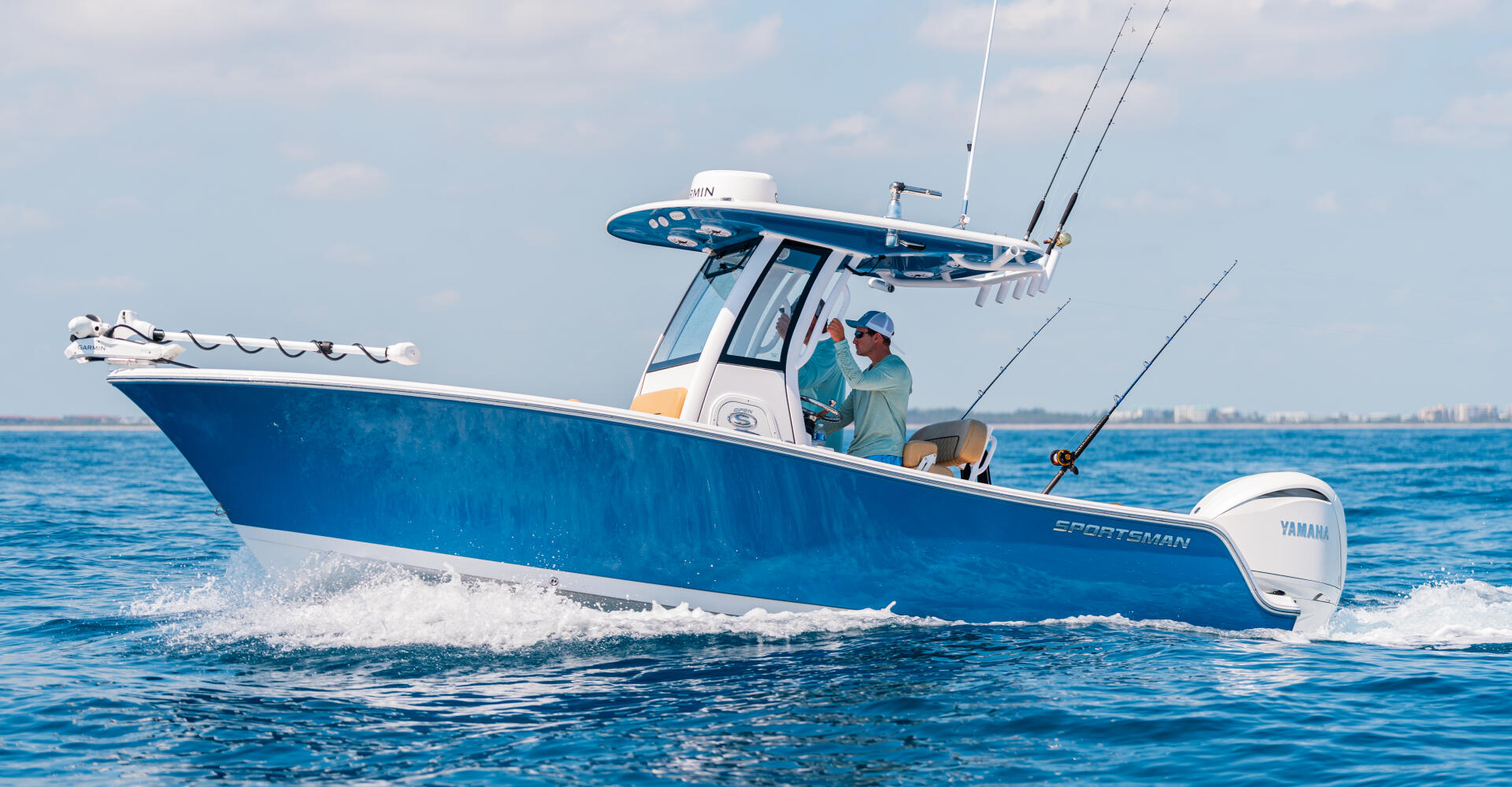 Blue and white center console fishing boat running offshore with two anglers aboard