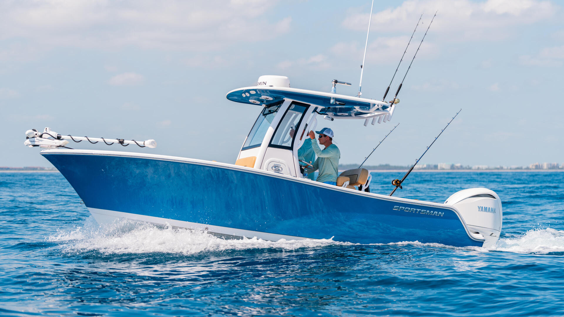 Blue and white center console fishing boat running offshore with two anglers aboard