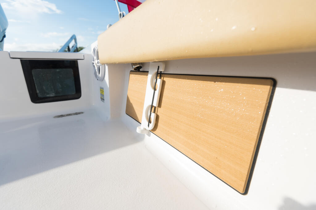 Teak storage compartments with stainless hardware mounted along the boat's gunwale