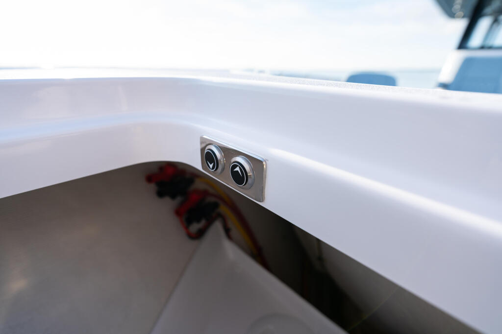 Dual flush-mount cupholders mounted on the white gunwale of a boat's cockpit, with calm water visible in the background