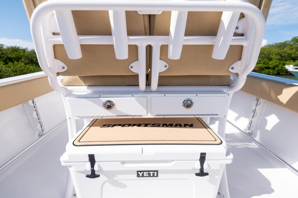 Open cooler and overhead storage compartment on center console boat with tan cushioned seating visible above