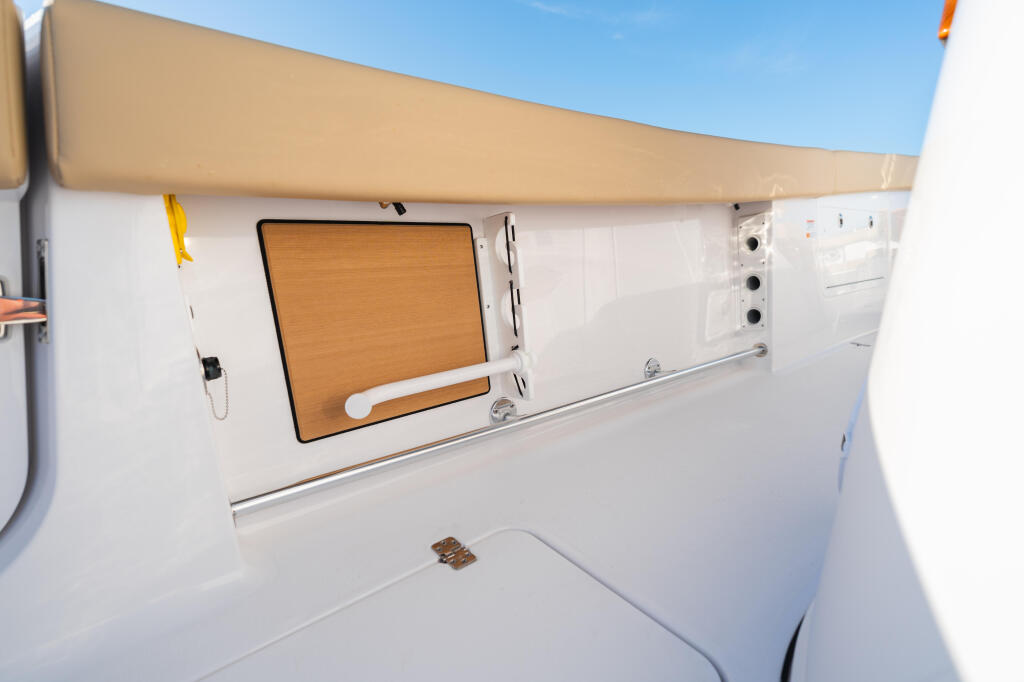 White cabin interior with wooden door, storage compartments, and tan hard-top canopy under clear sky