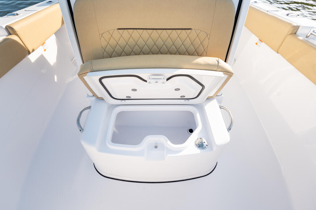 Open cooler with cushioned backrest and beige upholstered seating visible in center console boat