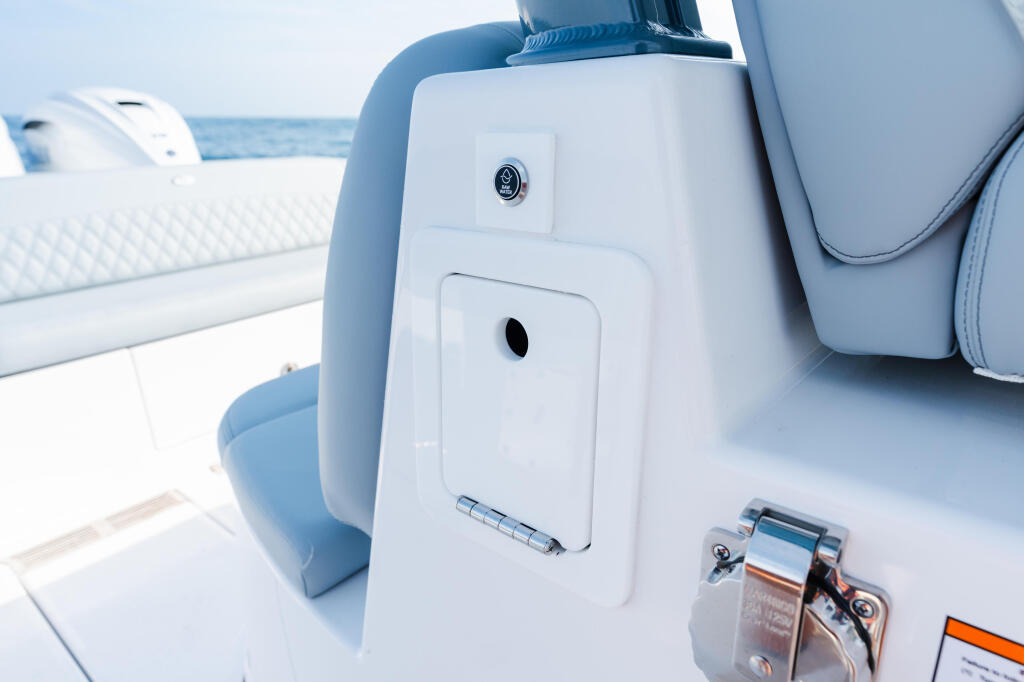 Close-up of boat helm control panel with camera and ventilation ports overlooking open water