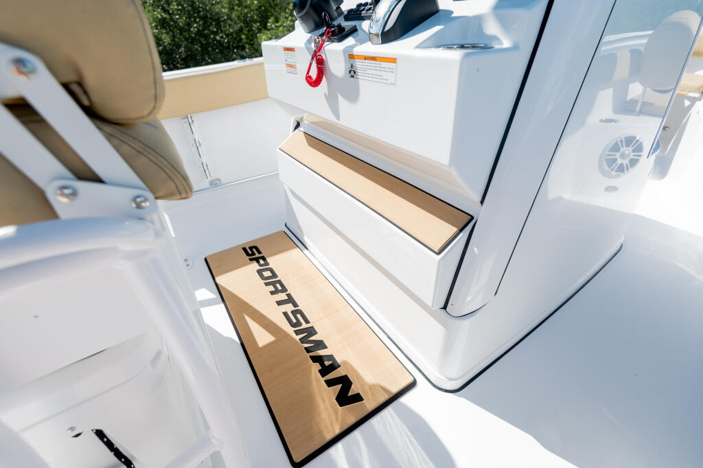 Extended teak footrest with Sportsman branding on center console boat