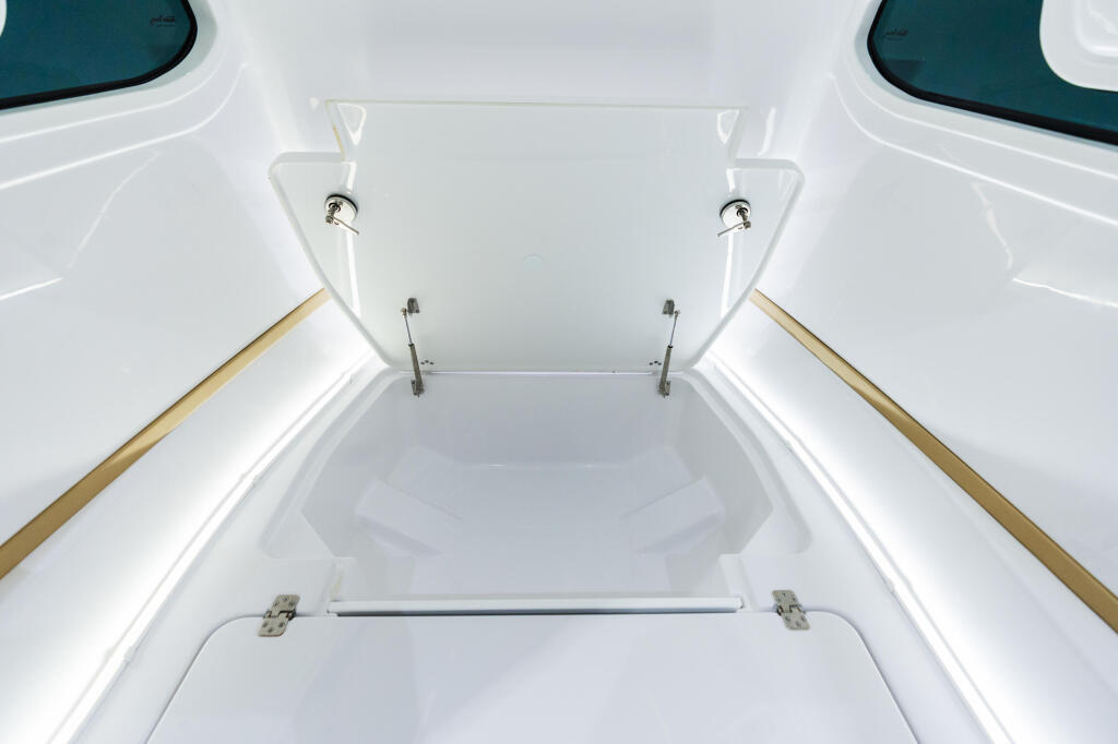 Open boat livewell with hinged lid and metal hardware, showing interior storage compartment
