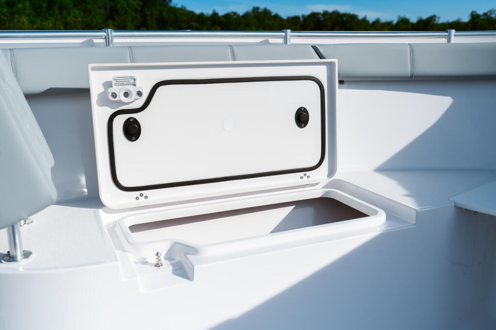 Open livewell with white cover and black latches on a center console boat deck