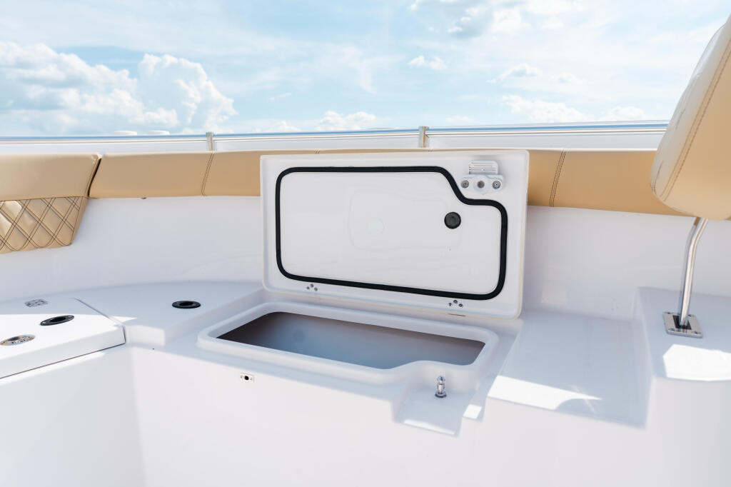 Boat livewell with open access door and control panel overlooking calm water