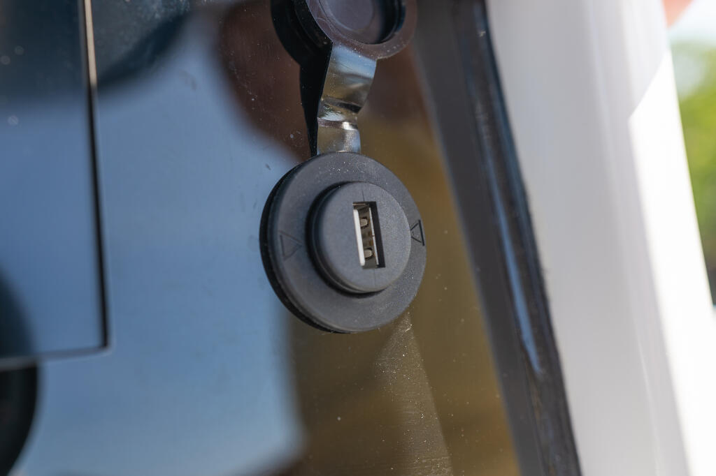USB charging port mounted on boat dashboard console with black protective cover