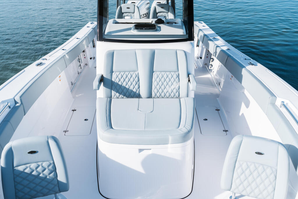 Open 322 center console boat viewed from above showing white seating, storage compartments, and helm area