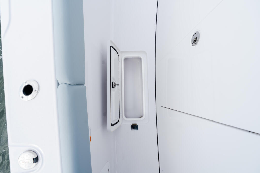 Cabin door and porthole details on a white boat hull with ventilation fixtures