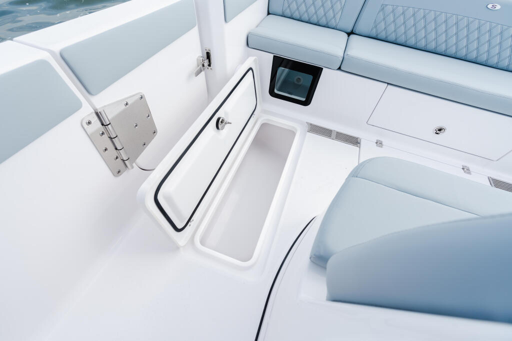 Cabin seating area with quilted upholstered seats, storage compartments, and electronics display