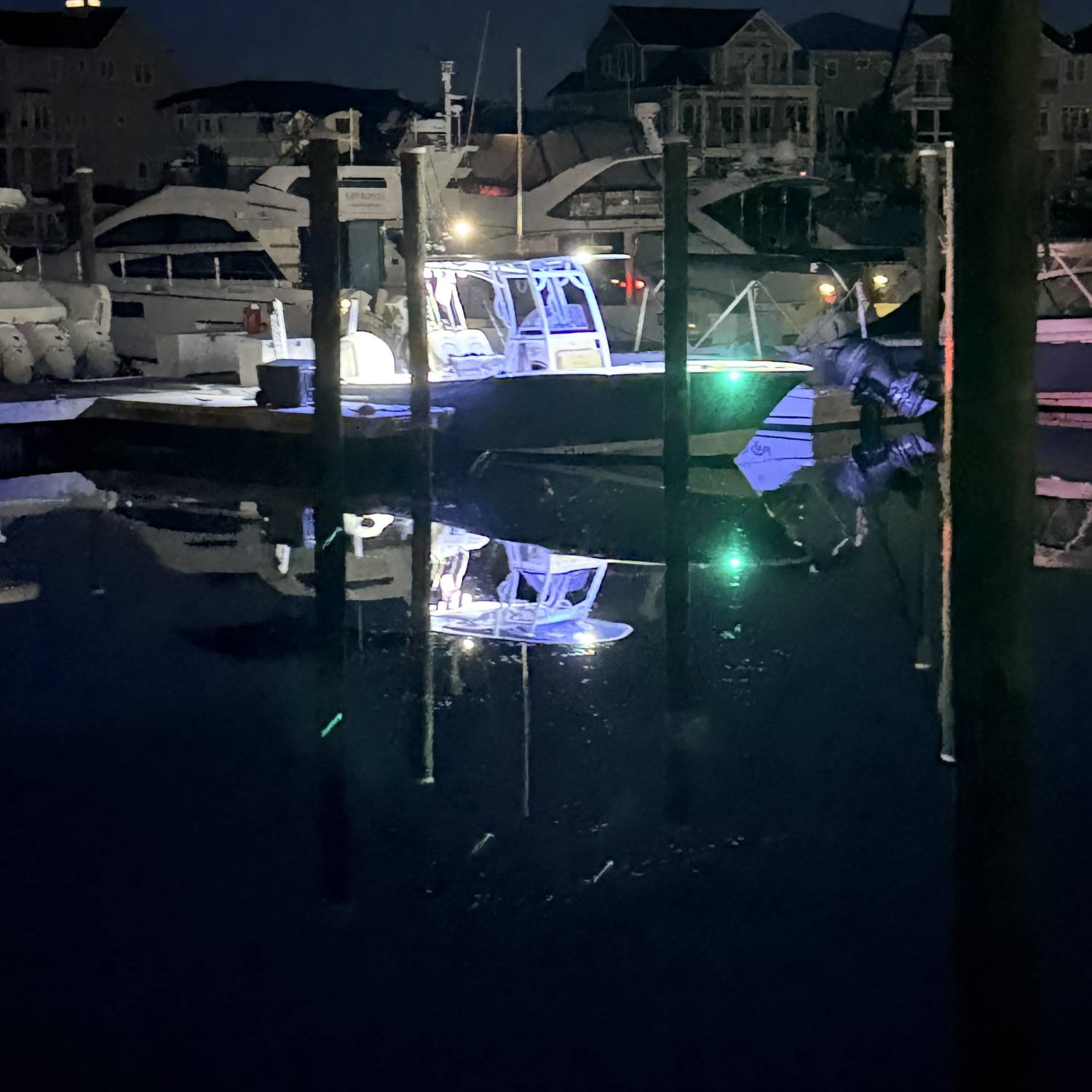 The bright deck lights reflecting on the dark, calm marina water give it a great "calm before t...